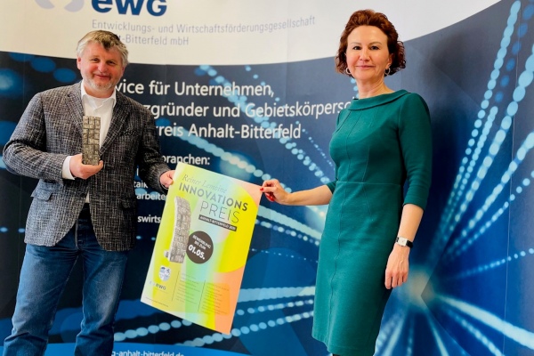 Landrat Uwe Schulze mit EWG Geschäftsführerin Elena Herzel mit Statuette und Plakat zum Reiner-Lemoine-Innovationspreis